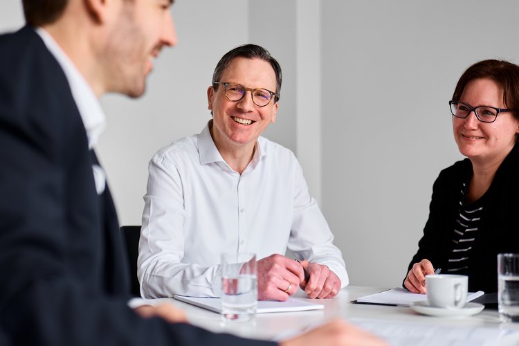 Zwei Männer und eine am Besprechungstisch